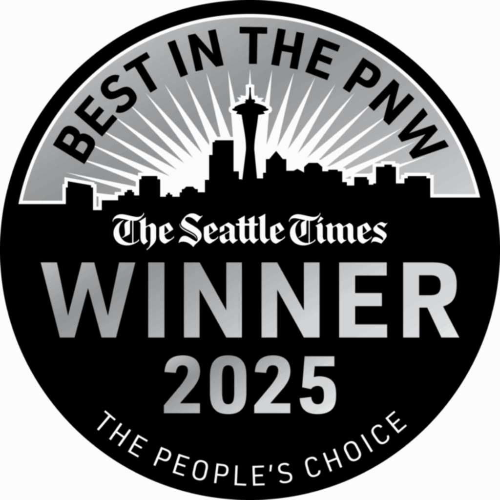 A circular award badge featuring the text "Best in the PNW" at the top and "Winner 2025" prominently displayed in the center. The Seattle skyline is silhouetted at the bottom, with sun rays emanating from behind. The badge includes the tagline "The People's Choice."
