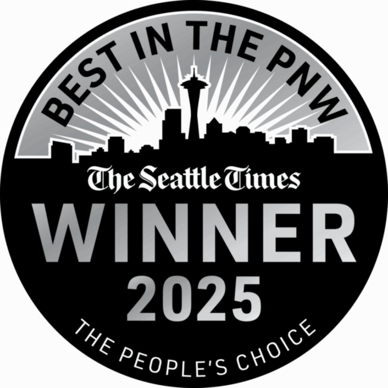 A circular award badge featuring the text "Best in the PNW" at the top and "Winner 2025" prominently displayed in the center. The Seattle skyline is silhouetted at the bottom, with sun rays emanating from behind. The badge includes the tagline "The People's Choice."