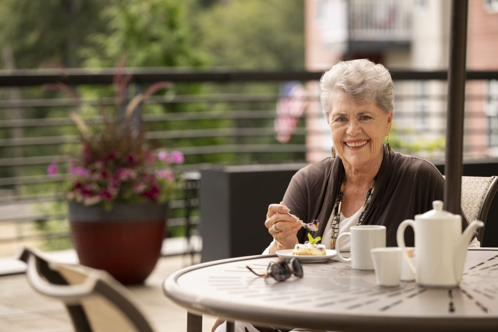 Woman sitting on the terrace at Heron's Key drinking coffee and enjoying an afternoon treat.